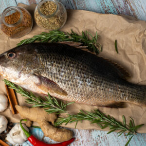 Fresh,Golden,Snapper,On,Wooden,Table,,Surrounded,By,Spices,And